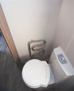 A heated towel rail, part of the Alde heating system, sits on the forward wall of the washroom