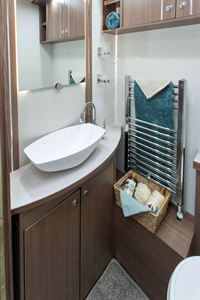 A large Alde heated towel rail next to the wash basin